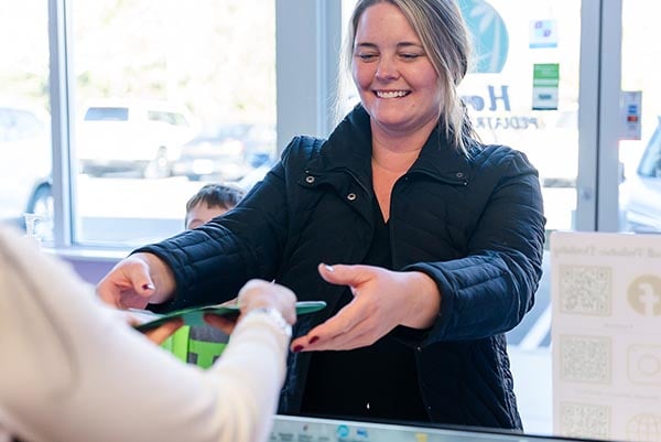 A parent taking notepad with forms from a receptionist