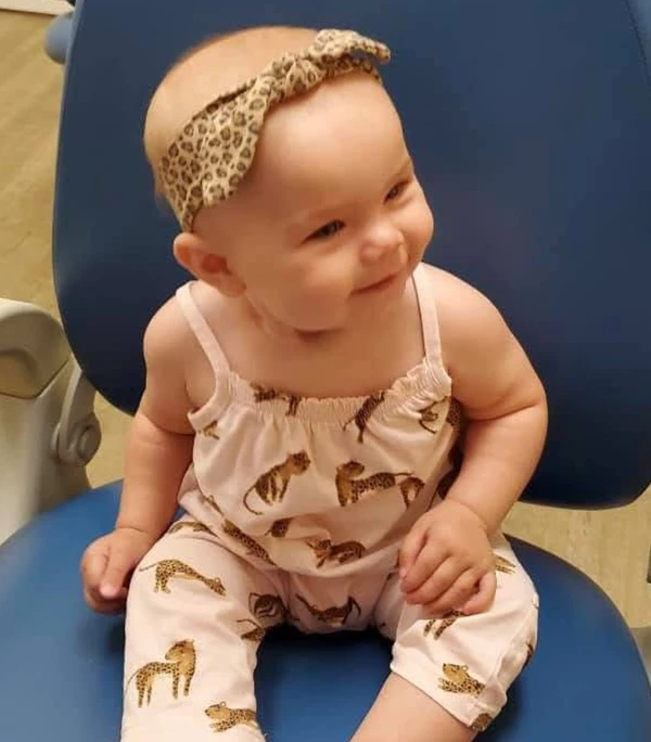 FirstVisit2 An infant sitting in a chair smiling