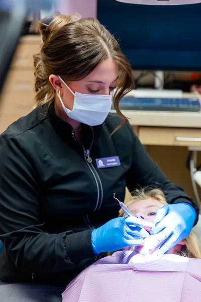 Preventive Dental Care for Children – Howell Pediatric Dentistry A dental hygienist doing preventive checkup during a patient appointment at Howell Pediatric Dentsitry